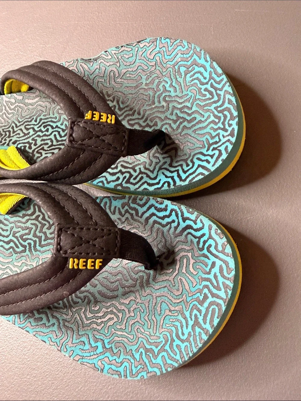 Kid’s Reef Blue & Black Patterned Flip Flops w/ yellow accent. Size: 2